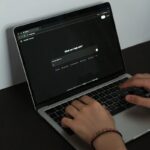 A person typing on a laptop on a table