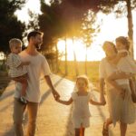Family walking on path with trees at sunset