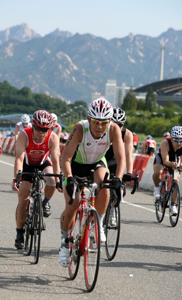 Atleta de triatlón cruzando la meta del Ironman 70.3 El Salvador 2026 en el Centro Histórico de San Salvador, símbolo del éxito deportivo y la transformación del país.