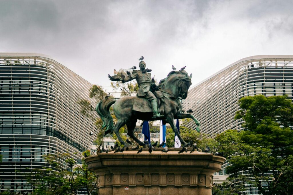 Dramatic statue of Gerardo Barrios in San Salvador with modern architecture backdrop.